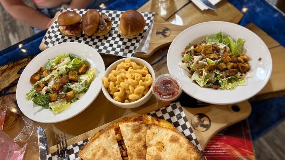 Table spread with sliders, mac and cheese, quesadilla and salads