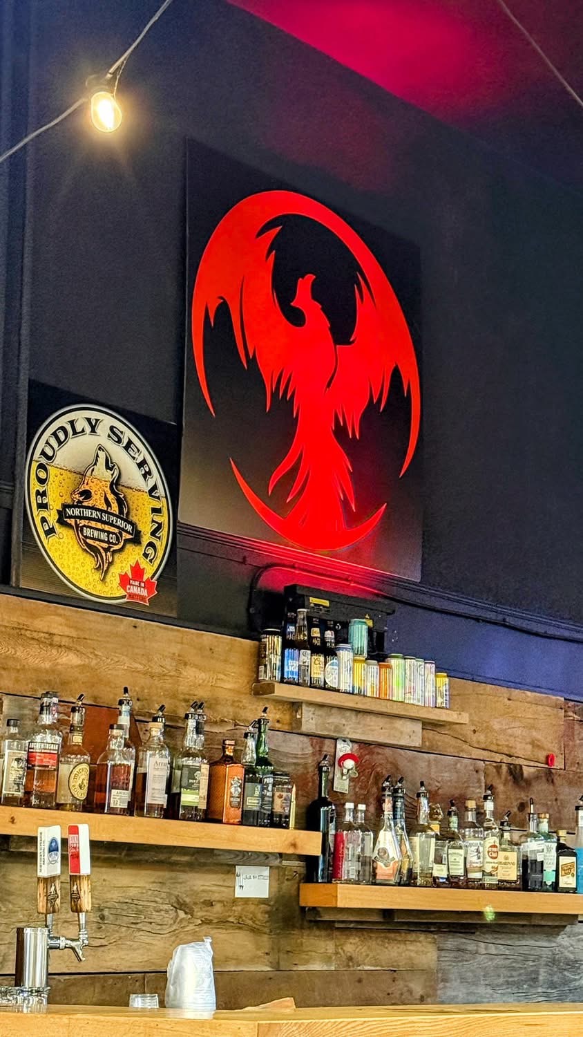 Red dragon logo mural behind the bar with reclaimed wood
